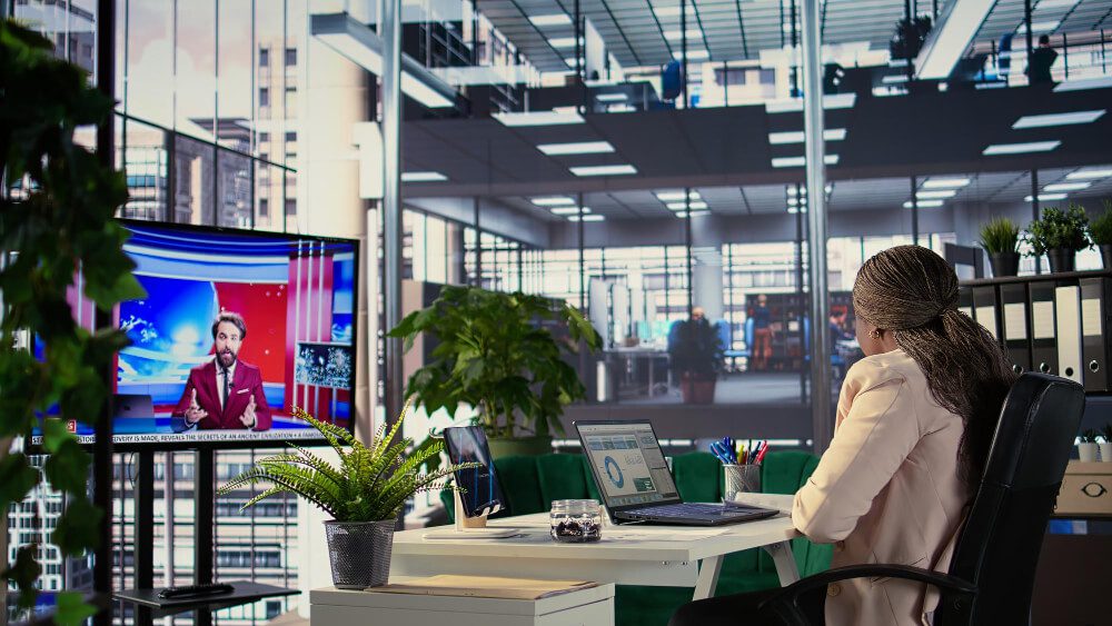 Modern newsroom featuring digital screens, collaborative workspaces, and multimedia production facilities